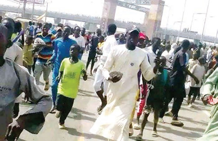 Buhari’s Kano visit: Protesting youths barricade roads, stone helicopter